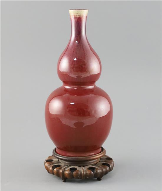 A Chinese sang de boeuf double gourd vase, 19th century H. 25cm, wood stand